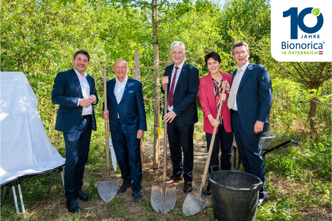 Leute vor einem Baum mit Schaufeln in der Hand