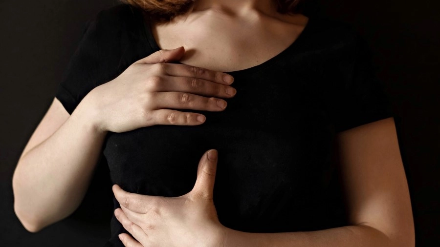 a-girl-in-a-black-t-shirt-clasps-her-chest