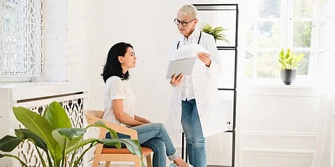 Gespräch zwischen Patientin und Ärztin – Symbolbild für die Frage: Wann zum Arzt bei PMS und Regelbeschwerden?