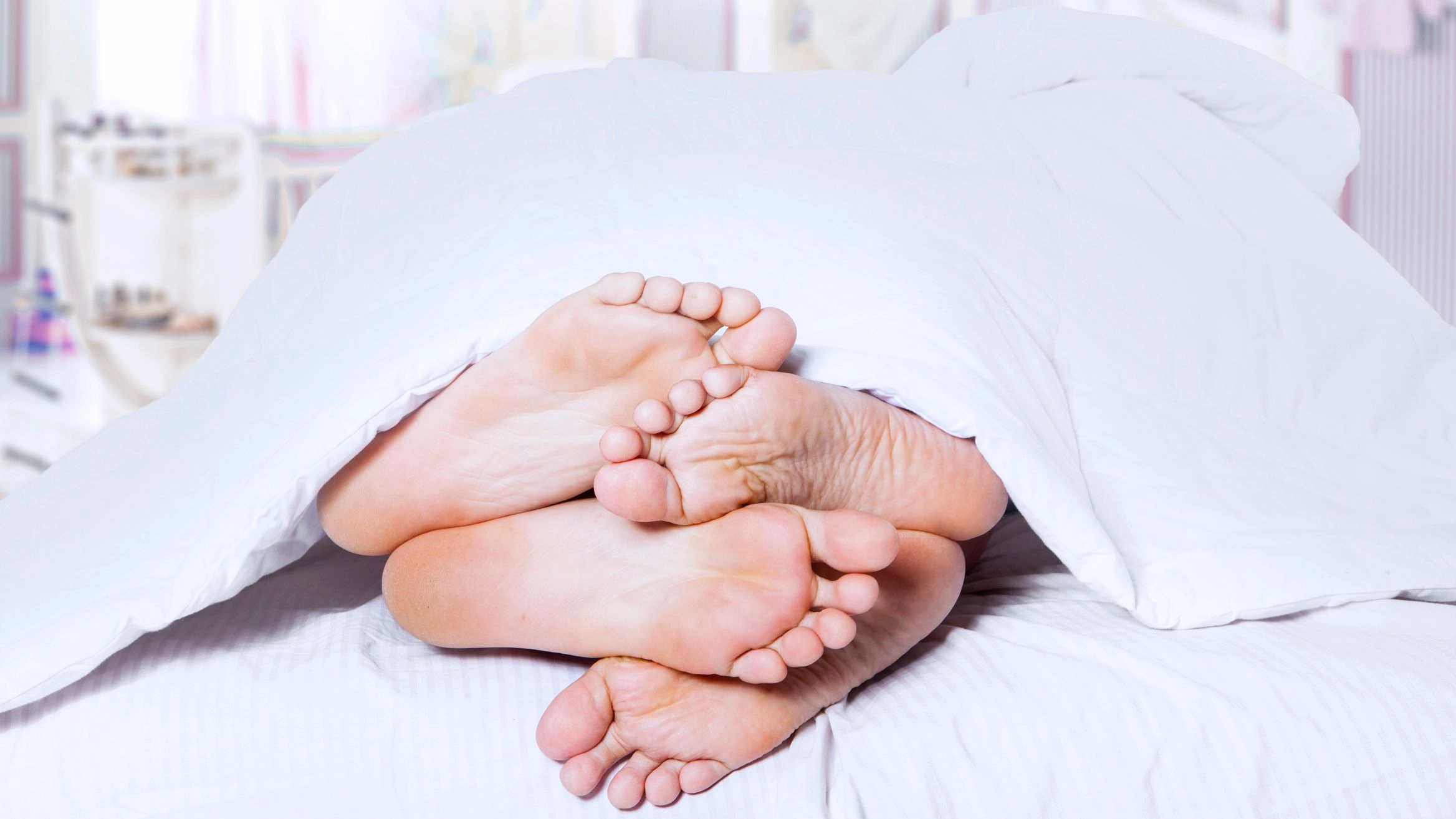 Füße unter Bettdecke