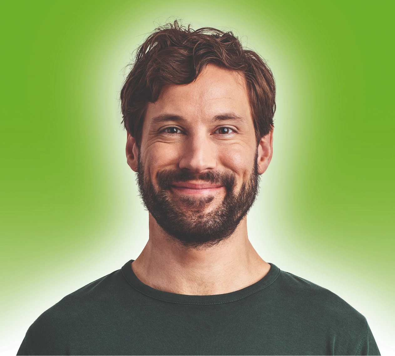 Gesicht eines Mannes der lächelt auf grünem Hintergrund