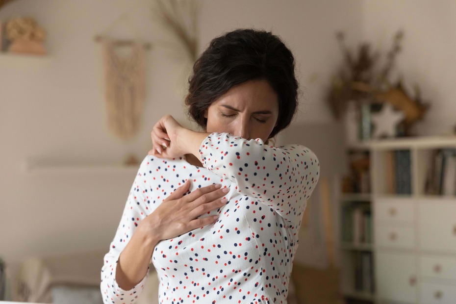Frau hustet in die Ellboge Bionorica