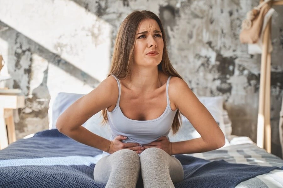 девушка страдает от боли в животе